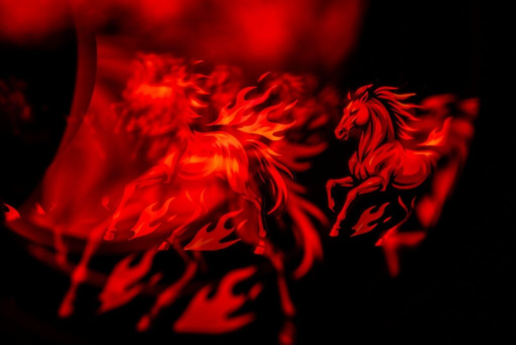 Two fiery horses running in the dark